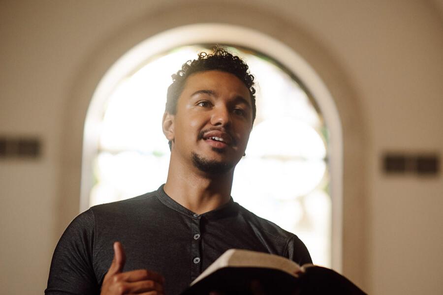 一个PBA学生站在教堂里拿着圣经